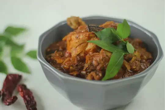 Kerala-style chicken roast garnished with curry leaves