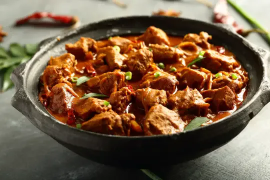 Kerala-style chicken curry served in a traditional dark bowl